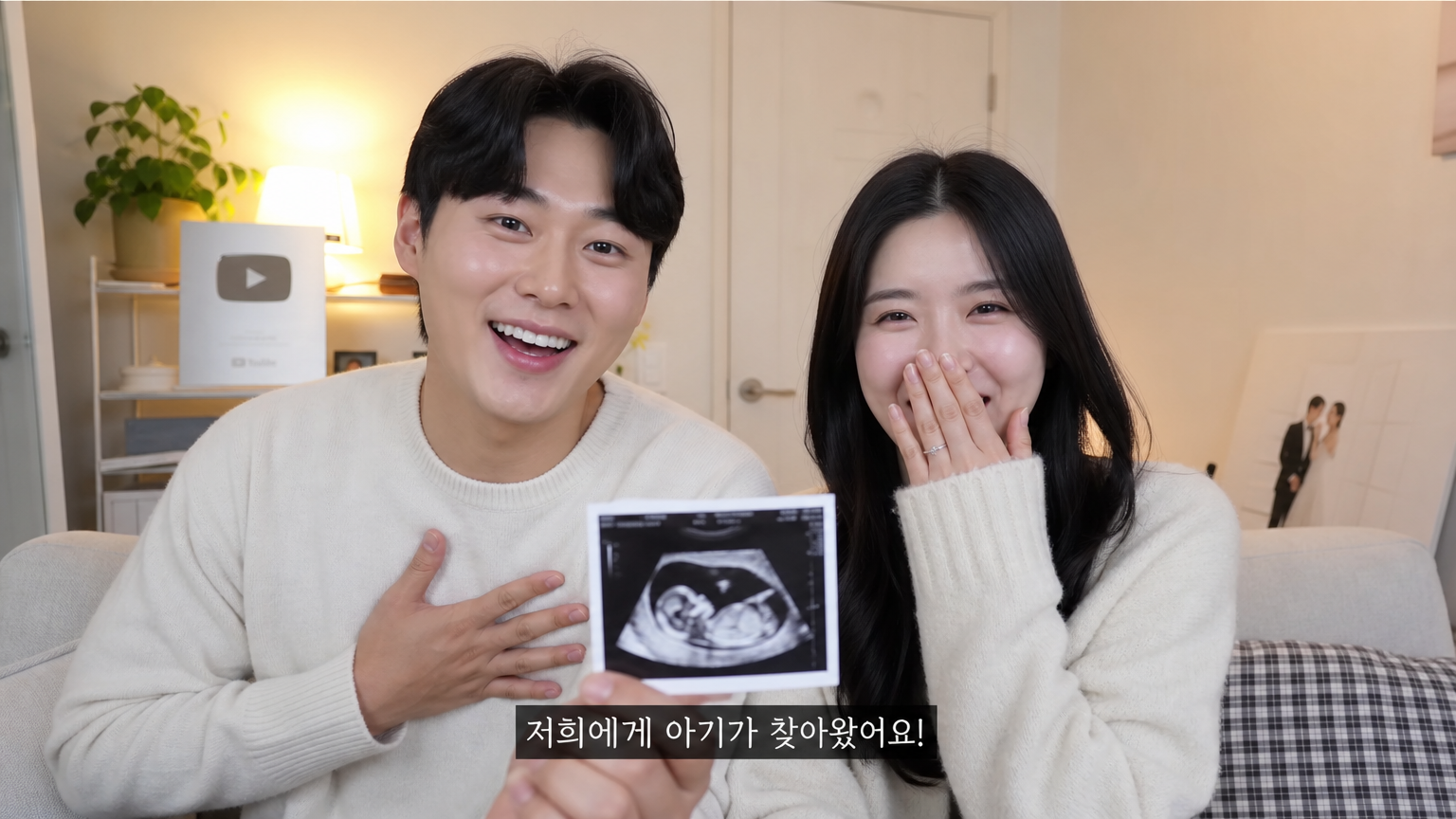 아늑한 거실에서 커플이 유튜브 채널을 통해 기쁜 소식을 나누는 장면