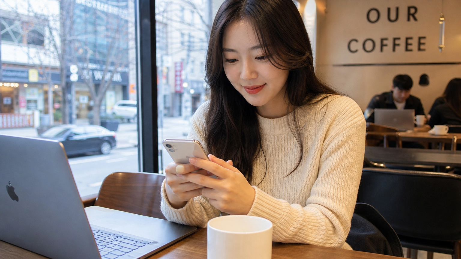 서울의 현대적인 카페에서 스마트폰 앱으로 디지털 온누리상품권을 사용하는 젊은 여성