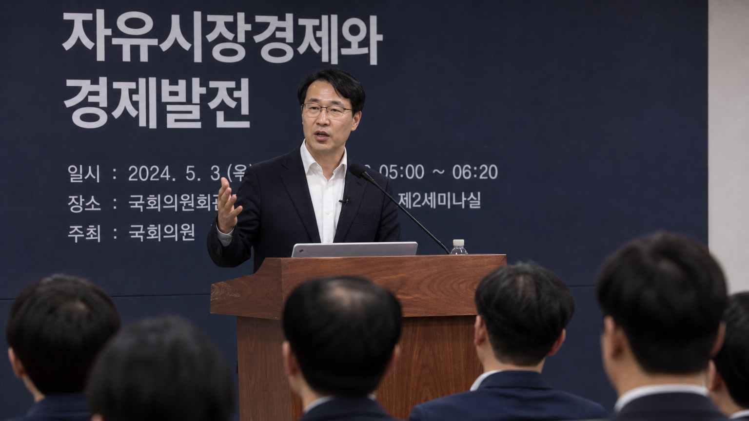 현대 한국 경제학자가 강연장에서 시장 경제 원칙에 대해 열정적으로 연설하는 모습