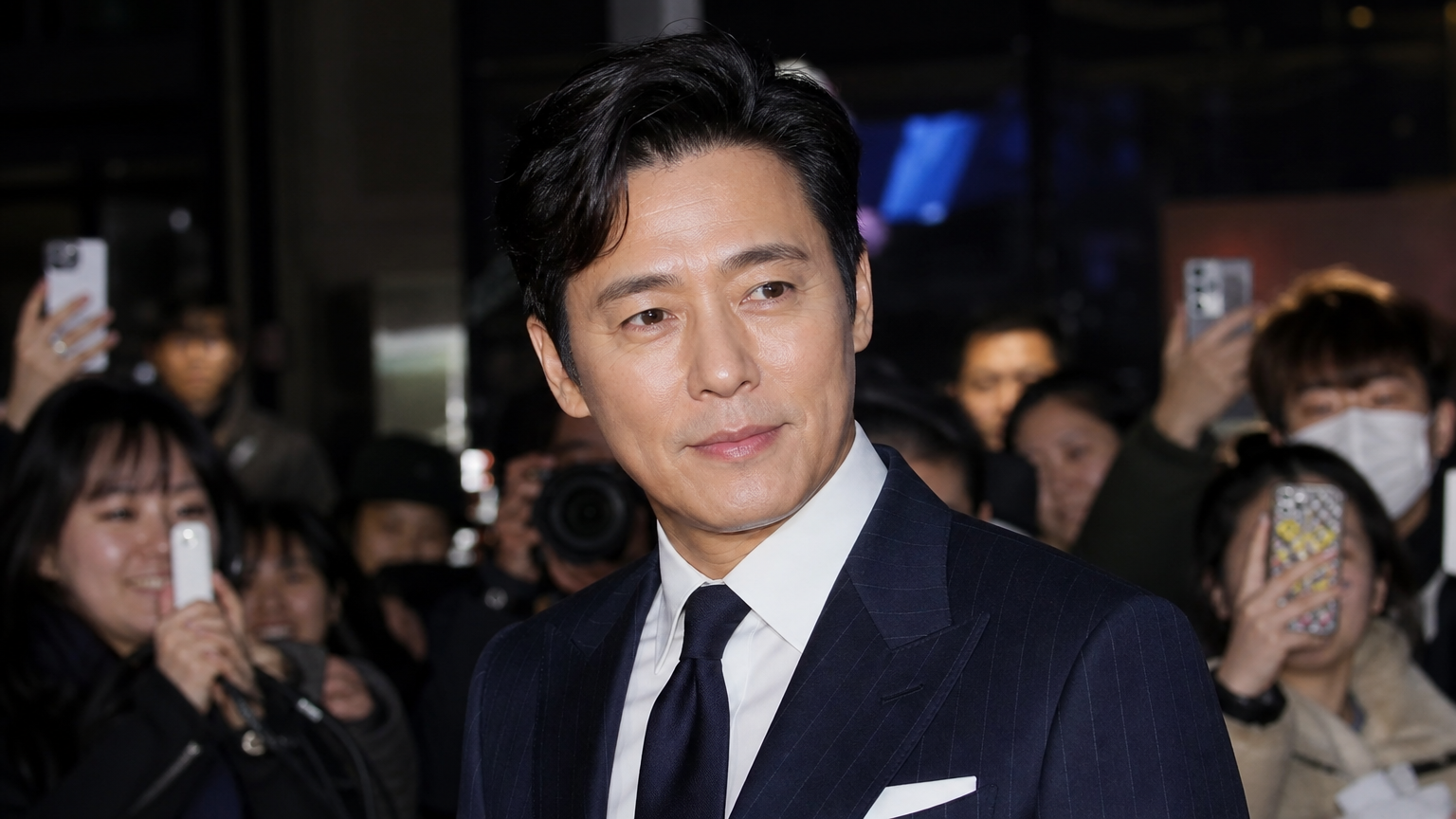 50대 중반의 매끄러운 피부를 가진 스타일리시한 배우가 행사장에서 주목받는 모습