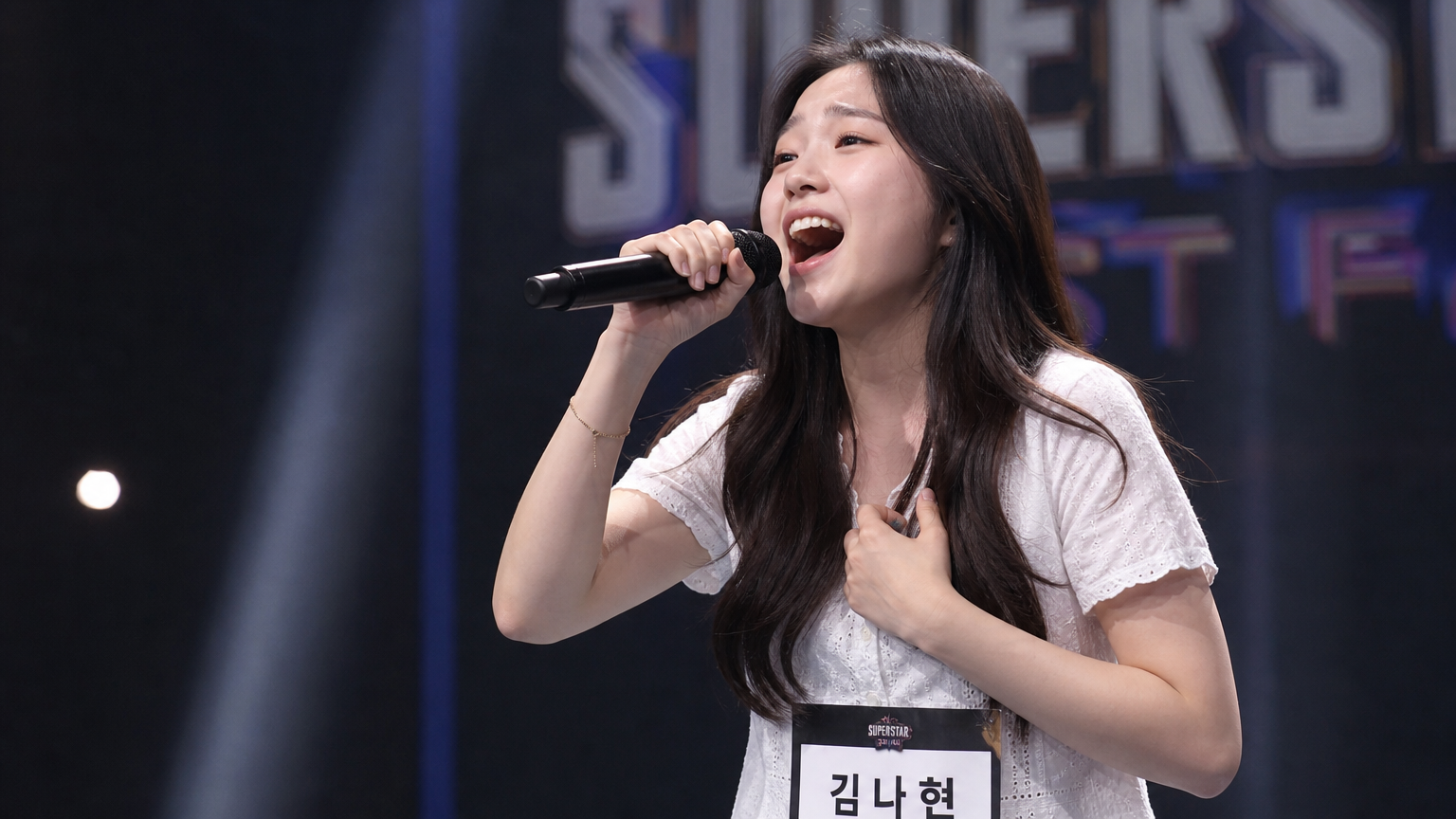 젊은 여배우가 오디션 무대에서 열정적으로 노래하는 장면