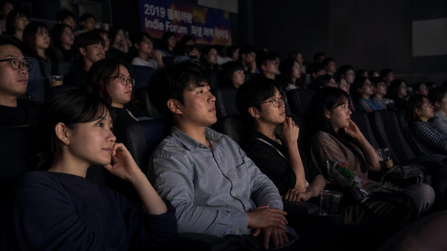 다양한 젊은 사람들이 영화관에서 독립영화제를 관람하는 장면