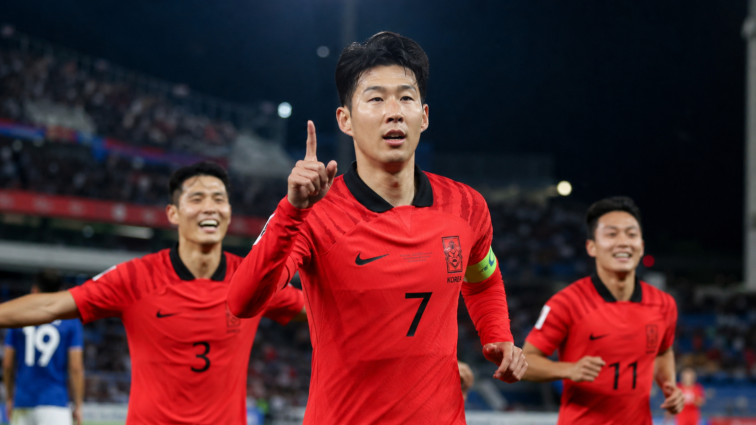 경기장에서 팀원들을 이끄는 젊은 한국 축구 선수