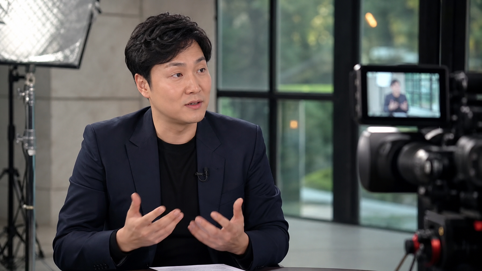 현대적인 방송 스튜디오에서 인터뷰를 진행하는 중인 남성