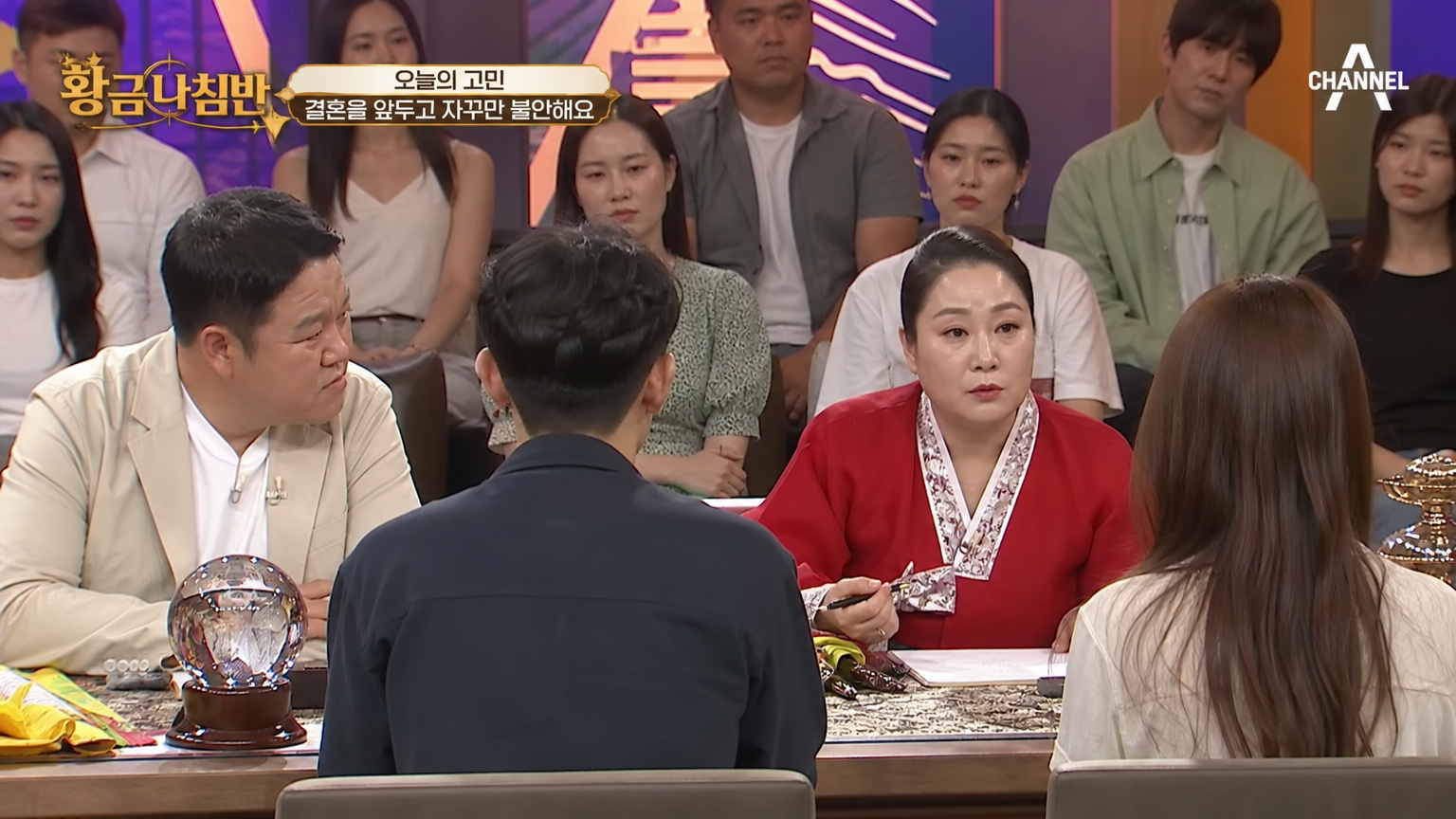 인기 TV 프로그램 세트장에서 진행자와 청중이 지켜보는 가운데 등장하는 역술가